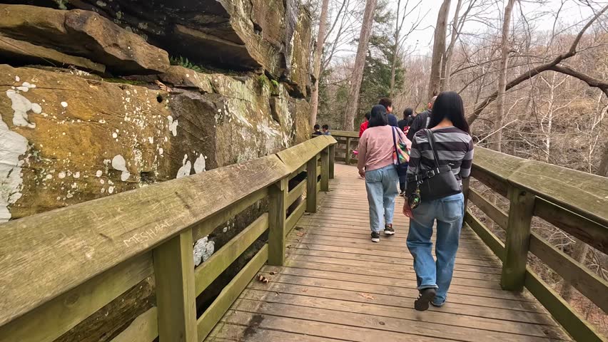 Explore the natural beauty of Brandywine Falls in Cuyahoga Valley National Park on a trail with stunning views. Visitors enjoy the scenic trail leading to Brandywine Falls, surrounded by trees and nat