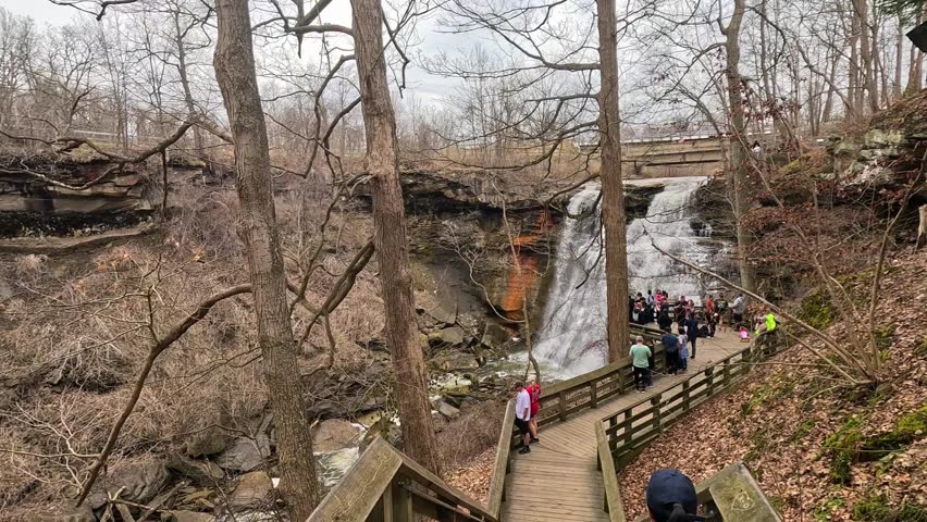 Explore the natural beauty of Brandywine Falls in Cuyahoga Valley National Park on a trail with stunning views. Visitors enjoy the scenic trail leading to Brandywine Falls, surrounded by trees and nat