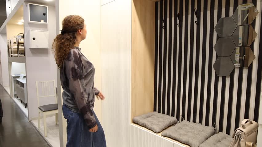 young beautiful woman finding herself new furniture, wardrobe in a store supermarket shop.