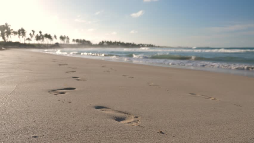 Sunset on macao beach with waves on the sea. Footprints on sandy shore. Bavaro shore. Dominican Republic