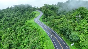 Aerial view of car driving on country road in forest. Cinematic drone shot flying over country road with curved in the mountain. - Powered by Shutterstock - Get 15% off with code: PIKWIZARD15