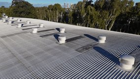 Aerial view of rooftop ventilation fans spinning under clear skies, highlighting industrial design and functionality in Gold Coast, Australia - Powered by Shutterstock - Get 15% off with code: PIKWIZARD15