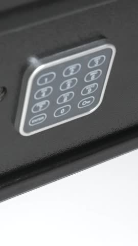 Vertical close up of a man hand open a digital combination lock of a black steel safe box and takes the one hundred dollar bills stack. Spent last money and becomes bankrupt 