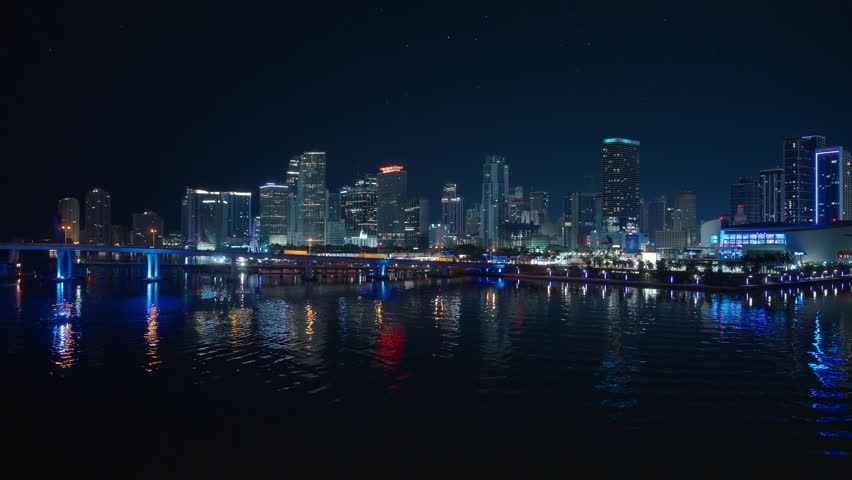Experience the breathtaking nighttime views of downtown Miami, where illuminated skyscrapers shine and the citys vibrant life unfolds along the scenic waterfront, creating a captivating atmosphere