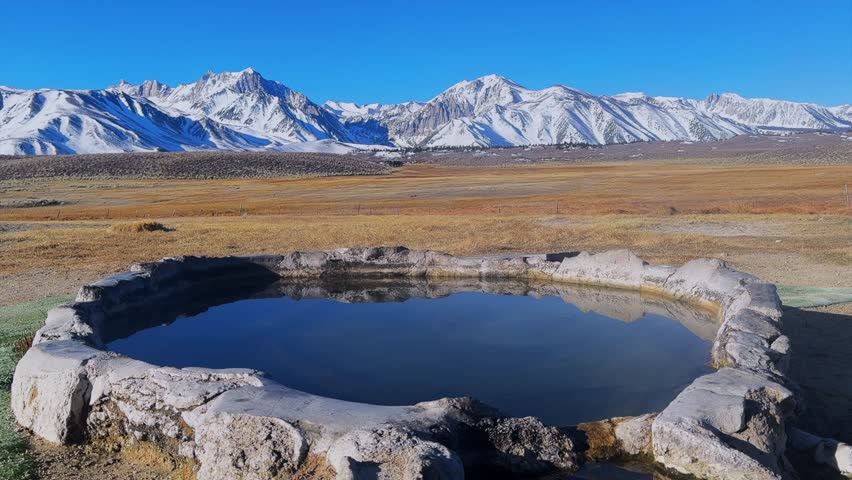 Winter early morning blue sky natural Hilltop Whitmore Wild Willys Hot Springs hot tub soak sunny sky snow covered Mammoth Mountain Minarets aerial drone Convict Canyon peaceful steam left slide