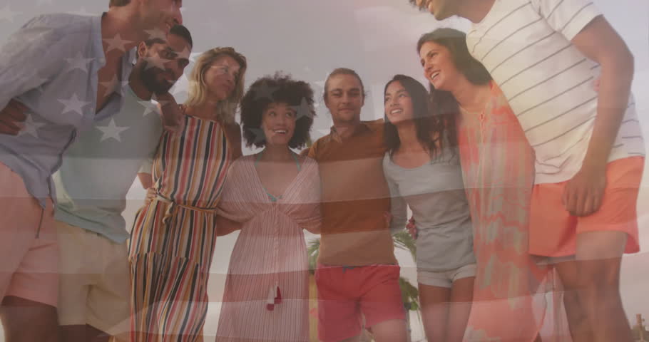 Eight friends leaning in and laughing at beach as flag overlay fading fueling patriotic marketing. Friendship, unity, celebration, camaraderie, diversity, summer, leisure