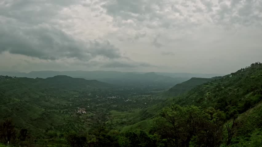Timelapse of dramatic monsoon clouds rolling over lush green mountains and dense tree cover in Panchgani, Maharashtra, India, capturing the raw beauty and changing moods of the rainy season 4K