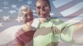 Man holding smartphone taking social media selfie as couple kissing on beach with US flag overlay. Romance, connection, affection, scenic, lifestyle, travel, happiness - Powered by Shutterstock - Get 15% off with code: PIKWIZARD15
