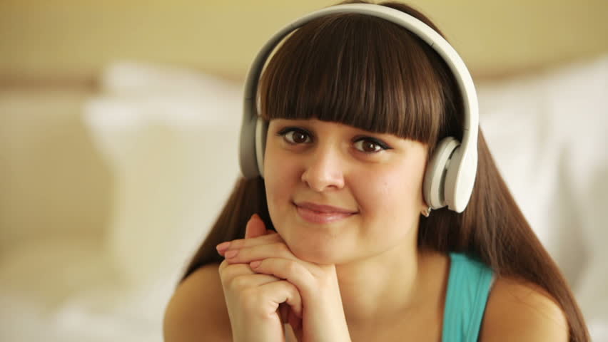 Teenager listening music and looking away with smile
