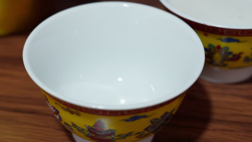 Butter tea flows into a yellow ceramic cup with vibrant patterns—highlighting traditional Tibetan beverage ritual and the tactile warmth of cultural hospitality.