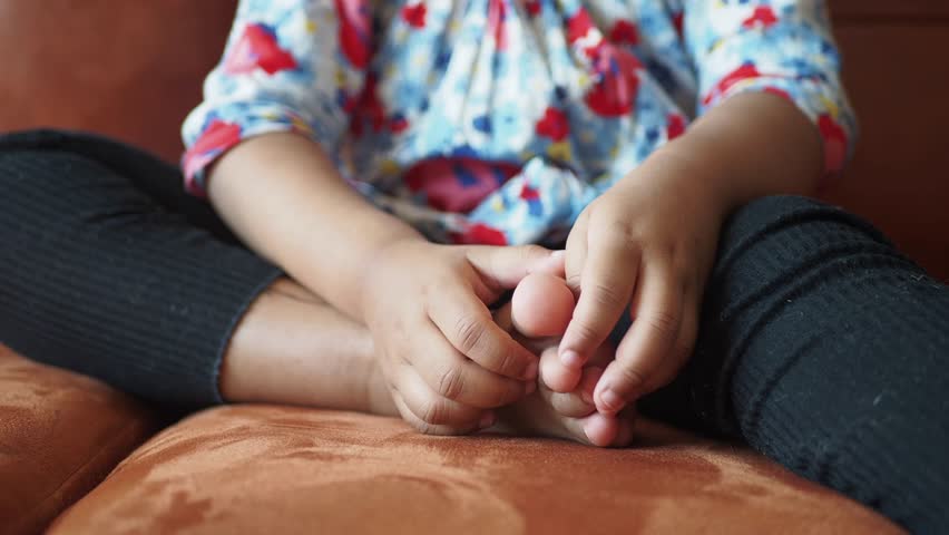 Child suffering itching skin on her feet 