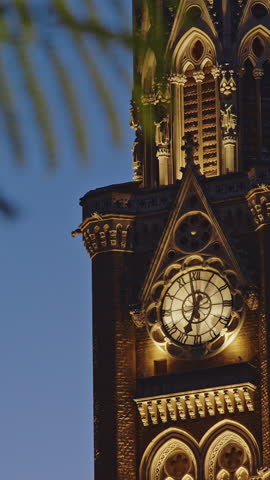 Close-up view on Rajabai Clock Tower In Evening Illumination. Clock Tower In Mumbai India. Confines Of Fort Campus Of University Of Mumbai. It Stands At Height Of 85 M or 280 Ft. Modeled It On Big Ben