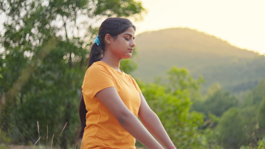 Pranamasana, meditation, yoga, young Indian woman making prayer pose hand gesture at outdoor in the early morning.