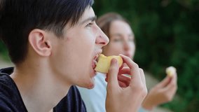 Boy with mother eating apple slices at healthy picnic, getting beneficial vitamins. Woman with boy eating apple slices during outdoor meal, absorbing healthy nutrients. Female with boy eating apple - Powered by Shutterstock - Get 15% off with code: PIKWIZARD15