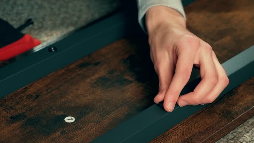 Man assembling furnishing, align table or secure wardrobe, using screwdriver. Craftsman hands polishing home details. Performing servicing or recalibration work