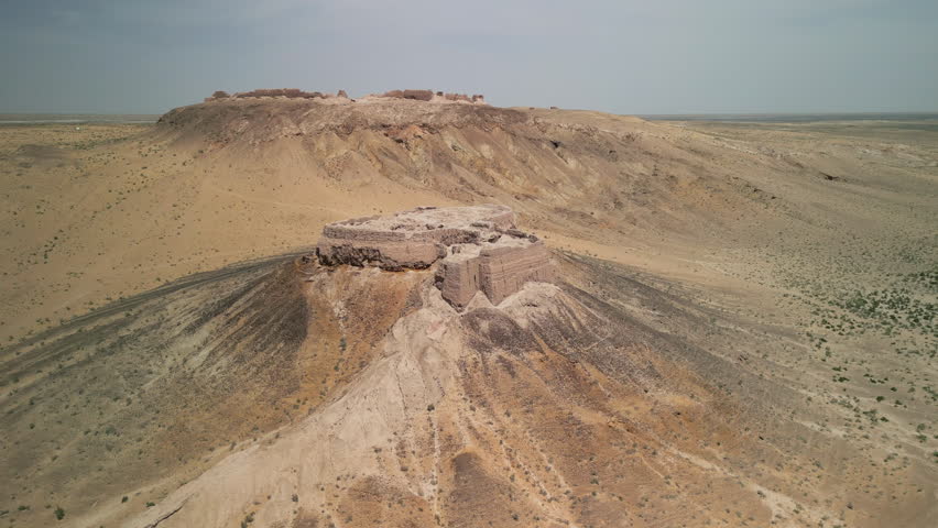 Aerial view showcases the historic Ayaz-Kala fortress in Uzbekistan. These ancient ruins date from the 4th century BCE to 7th century CE. The structure overlooks the vast Kyzylkum Desert landscape