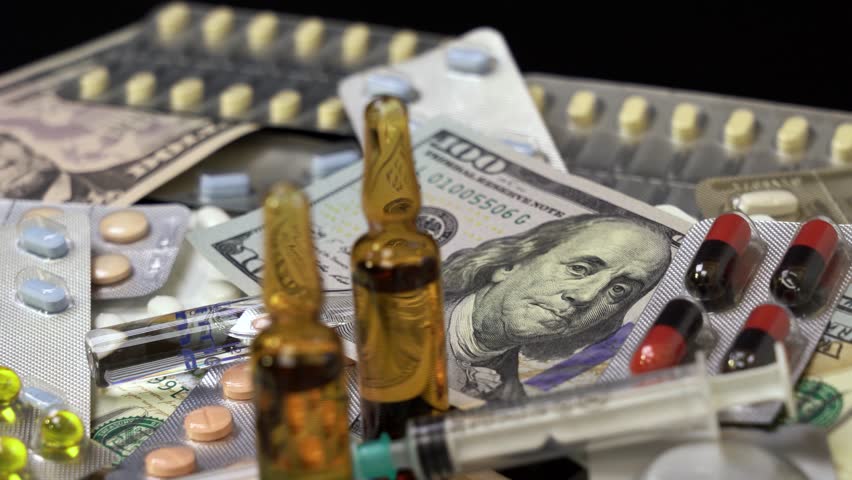Pills, Ampoule Medications, Syringes and US Dollar Bills Rotate on Black Background - Video Montage. 100 US dollar bills on a pile of medical pills, tablets, ampoules on a black background.