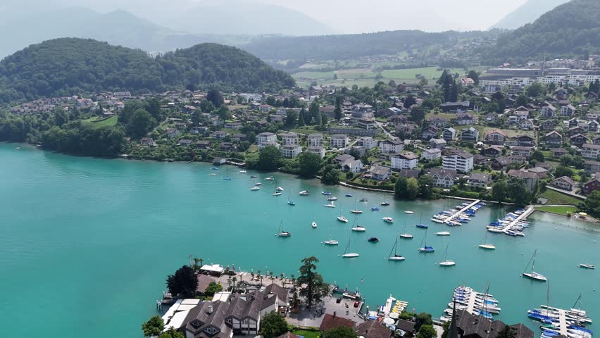 Spiez Town on lake Thun Switzerland pull back drone aerial reverse high angle
