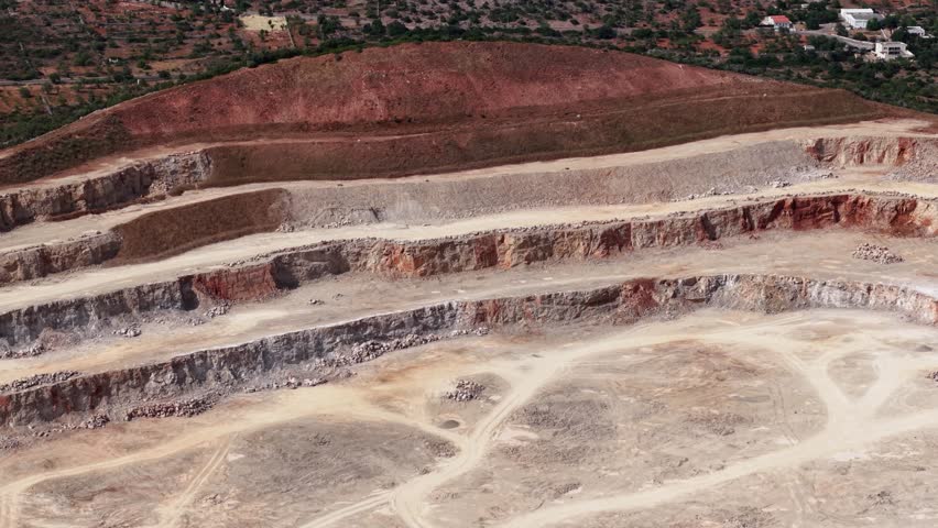 Exploration of a large quarry showcasing various mineral layers and terrain in a remote location