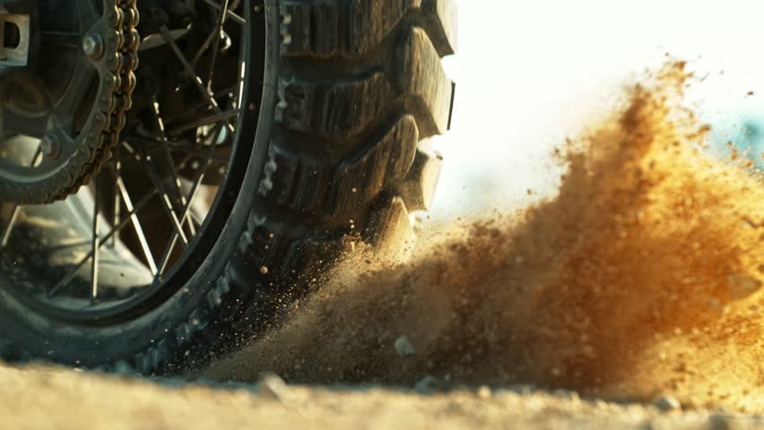 Super Slow Motion Shot of an Off-Road Motorcycle Spinning Its Rear Wheel and Throwing Dirt Into the Air. Captured at 1000fps to Highlight Power, Motion, and Explosive Terrain Impact. Speed Ramp Effect