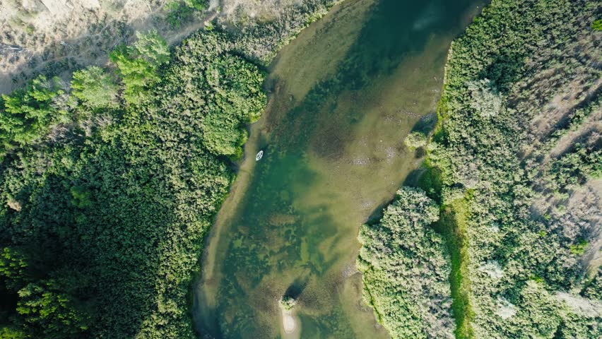 Top-down moment of a fly fishing guide boat. Framed in turquoise water with minimal movement.