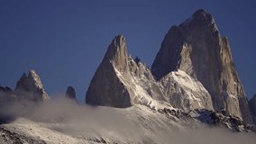 Time-lapse footage of Mount Fitz Roy and Aguja Poincenot in Patagonia, with low clouds drifting across the snowy peaks. Los Glaciares National Park. - Powered by Shutterstock - Get 15% off with code: PIKWIZARD15