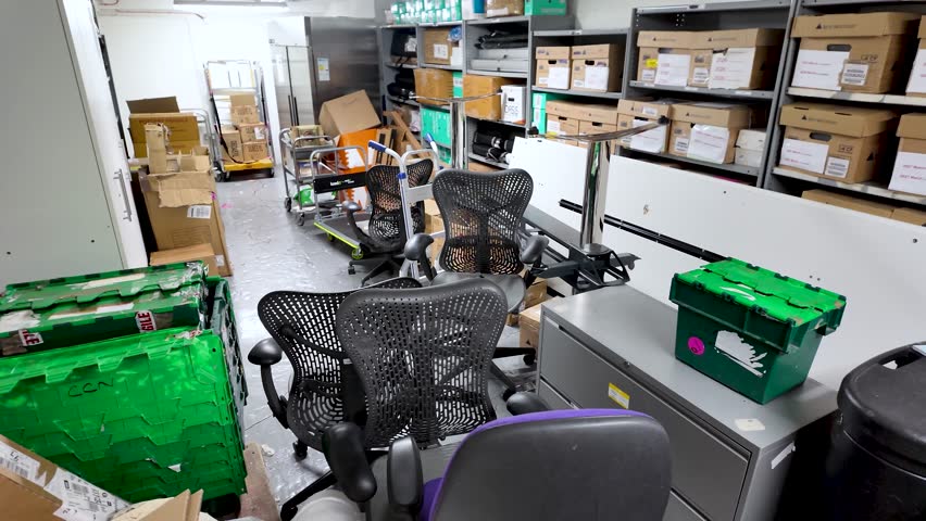 Office basement cluttered with chairs and storage boxes