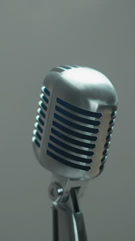 Elegant vintage microphone isolated against a softly blurred grey background, capturing a minimalist aesthetic