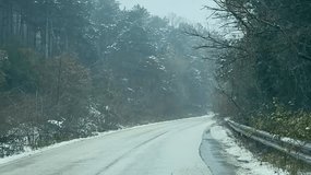 Scenic winter road trip to Mount Uludag, Turkiye, featuring a winding forest road covered with snow and misty pine trees. sstkTravel - Powered by Shutterstock - Get 15% off with code: PIKWIZARD15