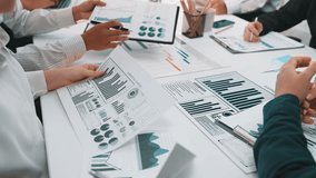 A business team collaborates on financial charts and data reports during a meeting in a modern office, showcasing teamwork and strategic discussions for successful outcomes. SACTR - Powered by Shutterstock - Get 15% off with code: PIKWIZARD15