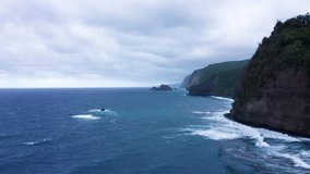 Dark blue ocean waves crash against towering cliffs covered in rich green foliage, while dense overcast clouds create a dramatic atmosphere along this rugged and wild coastline. - Powered by Shutterstock - Get 15% off with code: PIKWIZARD15