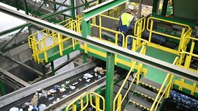 Employees meticulously sort various recyclable materials on a conveyor belt at a waste processing facility, ensuring efficient recycling practices occur. - Powered by Shutterstock - Get 15% off with code: PIKWIZARD15