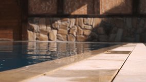 Close-up of wet tiles at the edge of a swimming pool with a stone wall in the background. Warm lighting and water reflections create a cozy and relaxing atmosphere
 - Powered by Shutterstock - Get 15% off with code: PIKWIZARD15