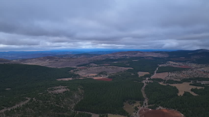 Aerial Landscape of Rugged Highlands, Fields, and Moody Overcast Sky