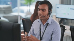 Indian call center professional working with global clients in a modern tech office. Delivering CRM support, customer service, and telemarketing advice in a culturally diverse workplace. - Powered by Shutterstock - Get 15% off with code: PIKWIZARD15