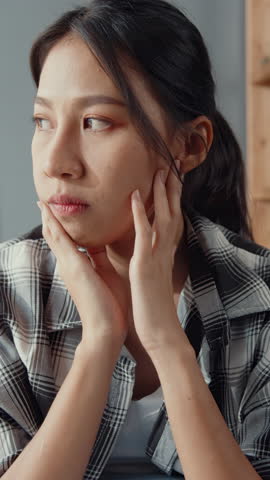 Vertical Screen : Upset asian couple wife sit on couch listen to furious husband yelling feel unhappy talk negative. Couple have fight or disagreement at home, Couple married toxic relationship.