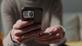 Close-up of a woman's hands holding and using her smartphone. She's wearing a sweater and a ring. - Powered by Shutterstock - Get 15% off with code: PIKWIZARD15