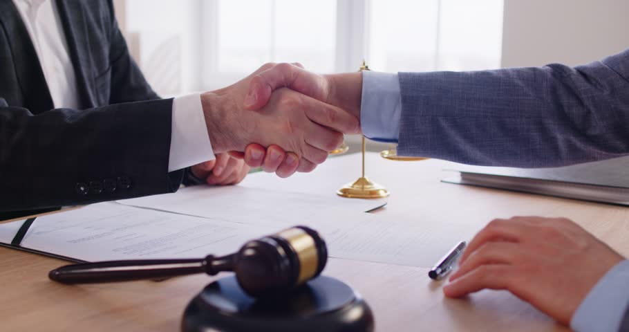 Man signing a contact with male advocate sitting on workplace. Male lawyer working in office during consultation with client sitting at desk. Legal law concept. 4k video. Slow motion.