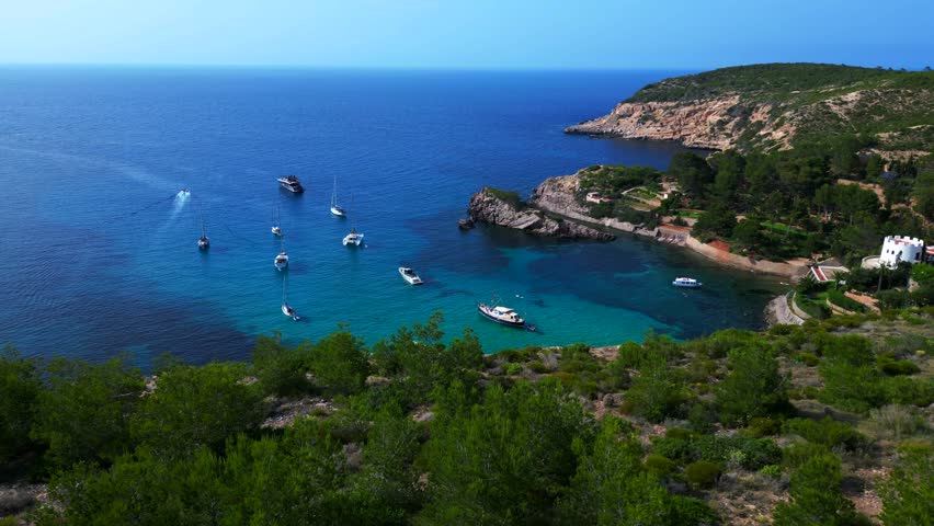 Sailboats yachts moored Ibiza blue water bay Smooth aerial view flight drone