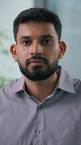 Vertical portrait in office Arabian Muslim business man posing in workplace serious calm businessman looking at camera male professional guy worker corporate CEO manager employer entrepreneur agent