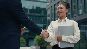 African American businesswoman woman female intern candidate holding folder smiling handshaking Caucasian man businessman male two multiracial business people in city shaking hands partnership hiring - Powered by Shutterstock - Get 15% off with code: PIKWIZARD15