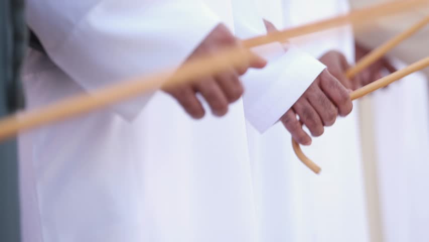 Traditional Emirati al Ayala male dance, cultural UAE heritage. Hands in frame.