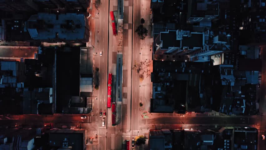Top-down drone view of Bogotá streets with TransMilenio buses at night – Bogotá, Colombia