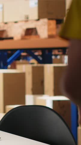 Vertical Video Warehouse worker scanning airway bills labels applied on cargo packages, monitoring shipping route on package tracking software. Registering the details for the logistics. Camera B.