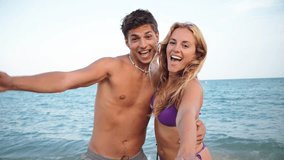 A cheerful couple enjoying their time together at the beach, radiating happiness and love while having fun in the sun on a warm day, creating unforgettable memories by the serene coastline. - Powered by Shutterstock - Get 15% off with code: PIKWIZARD15