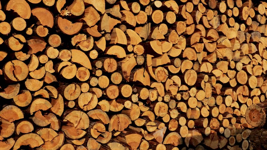 Firewood background. solid fuel.stack of chopped firewood. Preparation and storage of firewood for the heating season. Natural source of heat and heating of the house. 4k footage