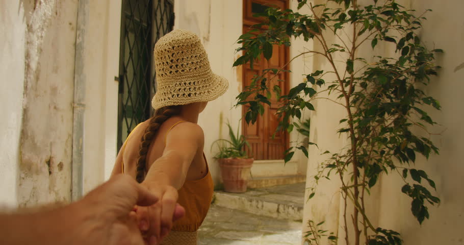 Woman leads by hand through a cozy courtyard in a historic town Atrani in Italy