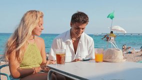 Joyful couple captures a delightful moment on a sunny beach day while sipping drinks at a lively bar, showcasing the essence of summer vacations and love in a picturesque coastal setting. - Powered by Shutterstock - Get 15% off with code: PIKWIZARD15