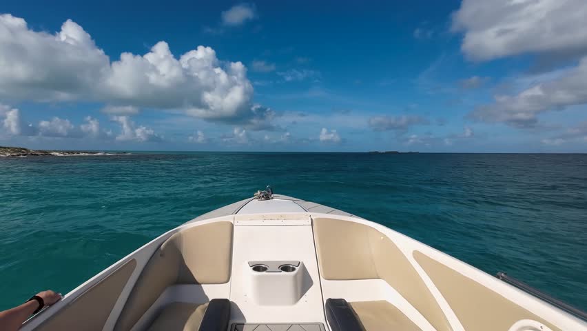POV front view of speeding motorboat cruising over blue Caribbean Sea.
