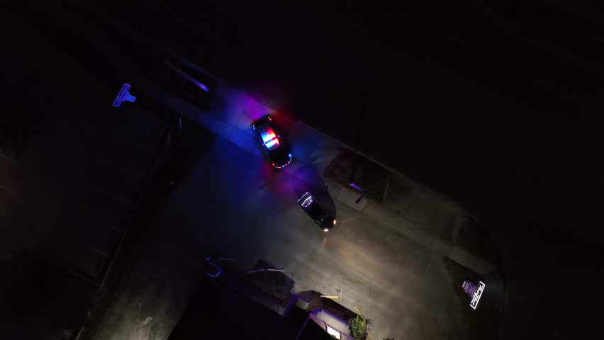 Police Car with flashing blue and red lights after car chase at night. American suburb district in Florida. Police check